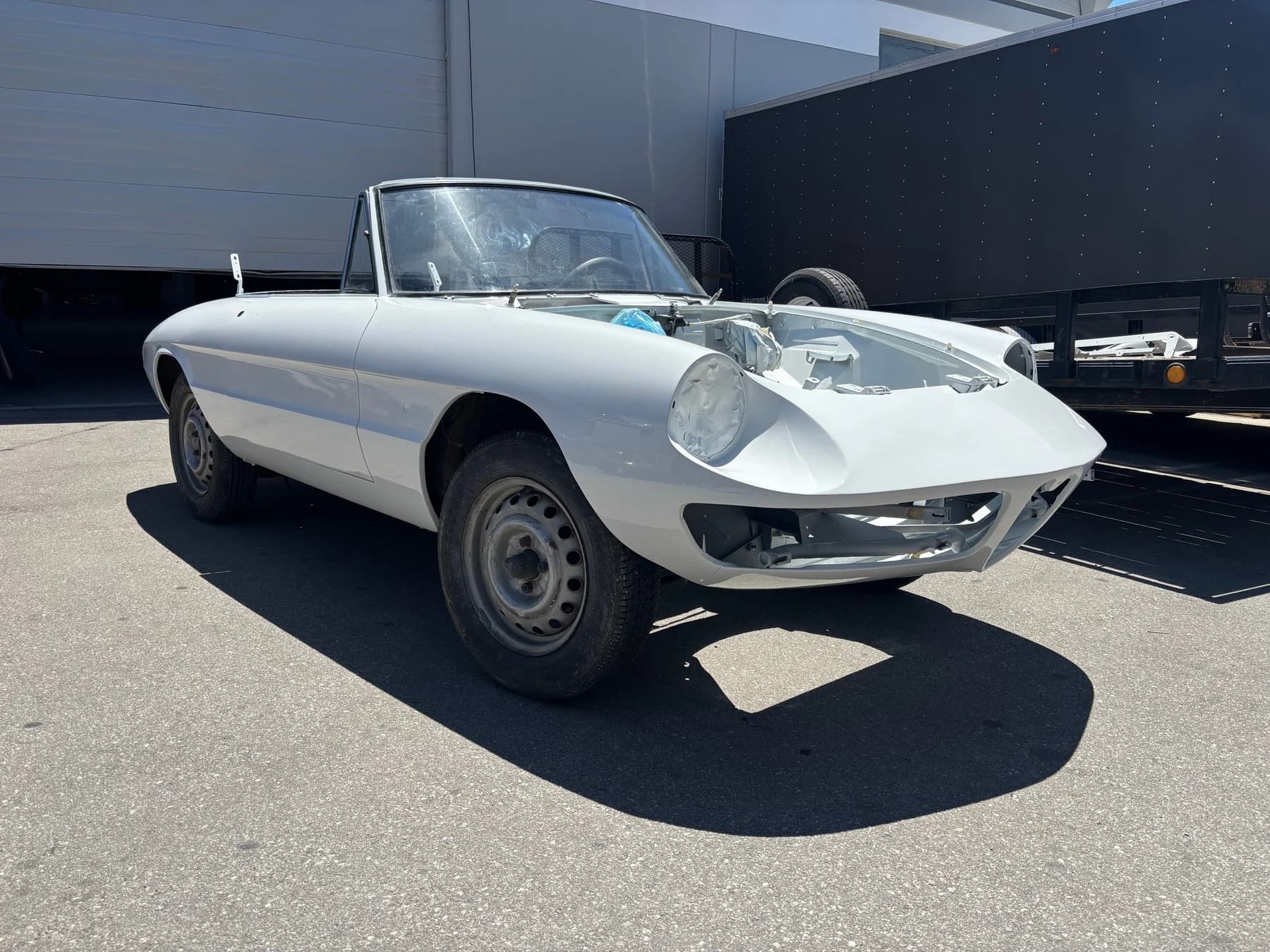 The Alfa Romeo Duetto outdoors during restoration.