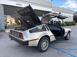 The actual DeLorean with its gullwing doors open.