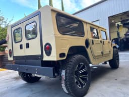 Rear exterior view of the tan Humvee.