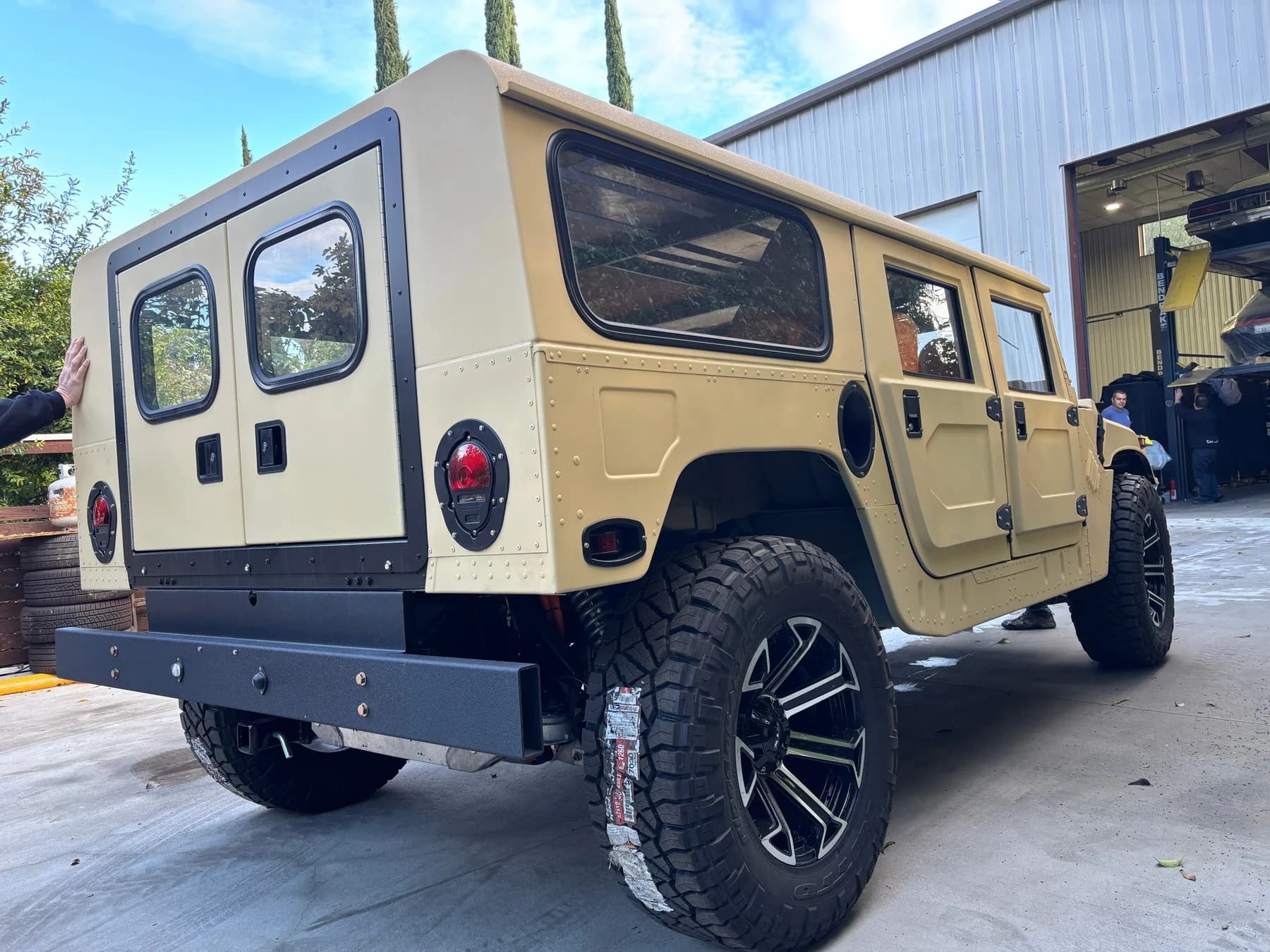 Rear exterior view of the tan Humvee.