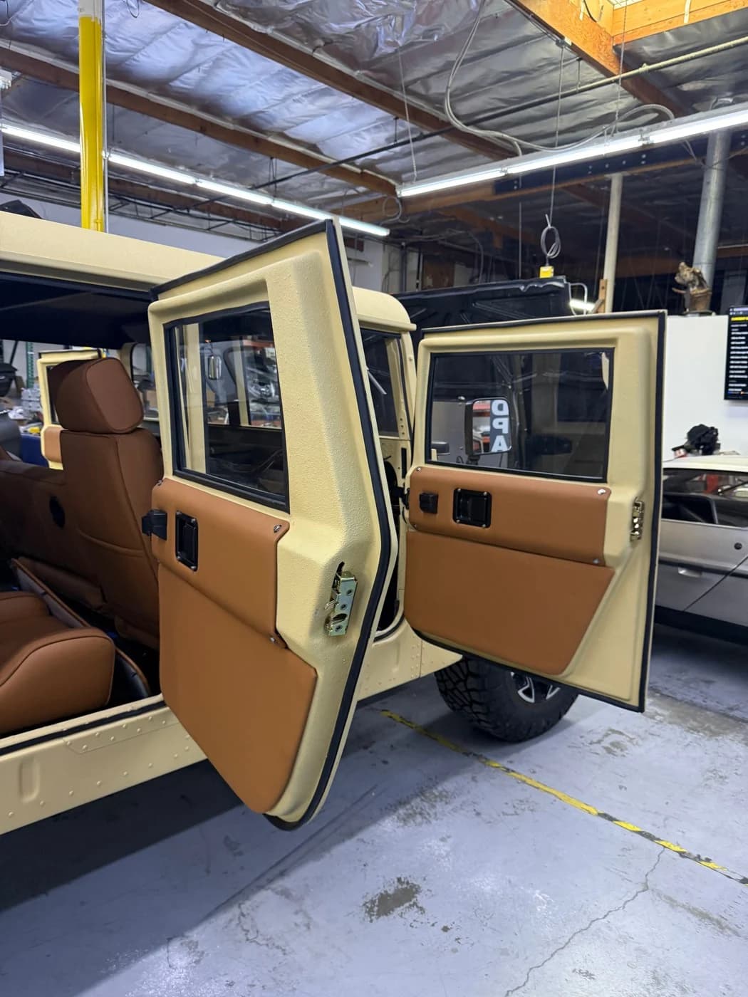 Door and cabin work on the tan Humvee.